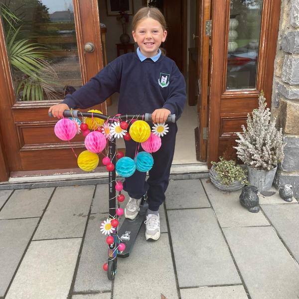 girl with decorated scooter in school uniform