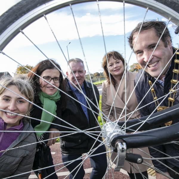 mayor and others look through spokes of bicycle