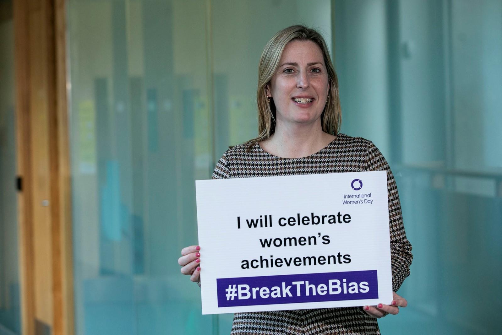 Mayor holding sign for international womens day 2022 at county hall. Sign reads celebrating womens acheivements.