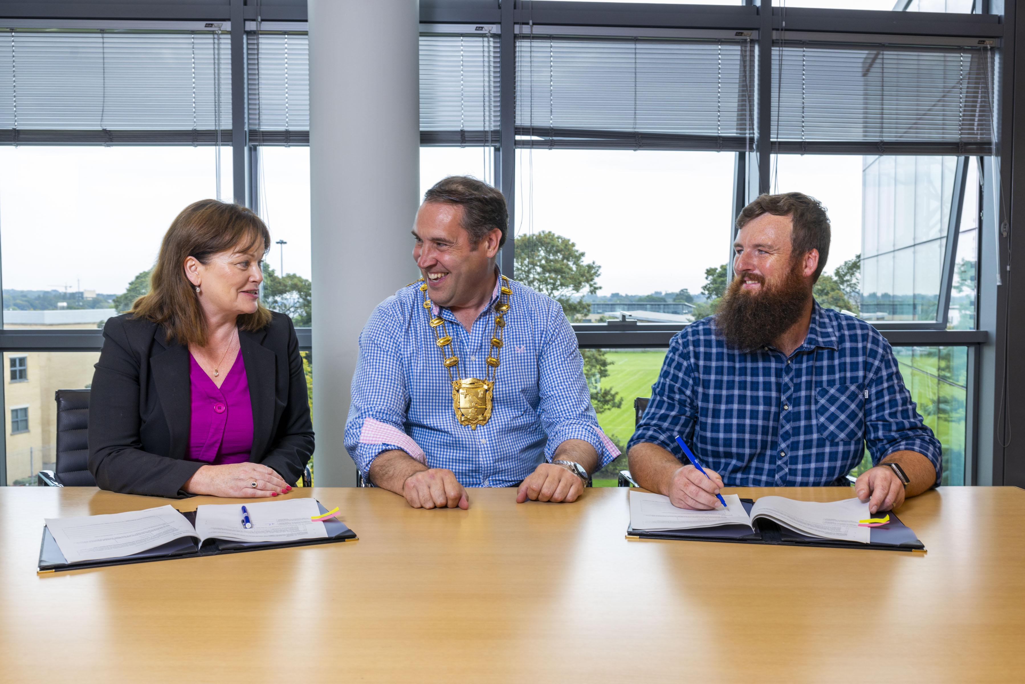 Mayor, Chief Executive and Contractor signing contracts at desk