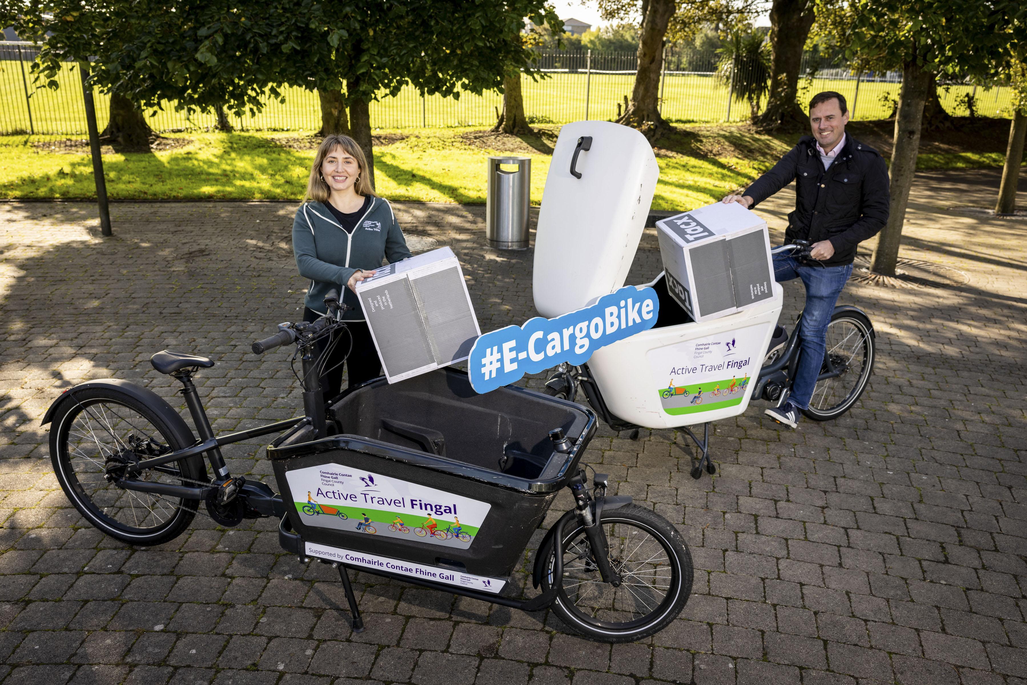 man and woman with ecargo bike each outdoors